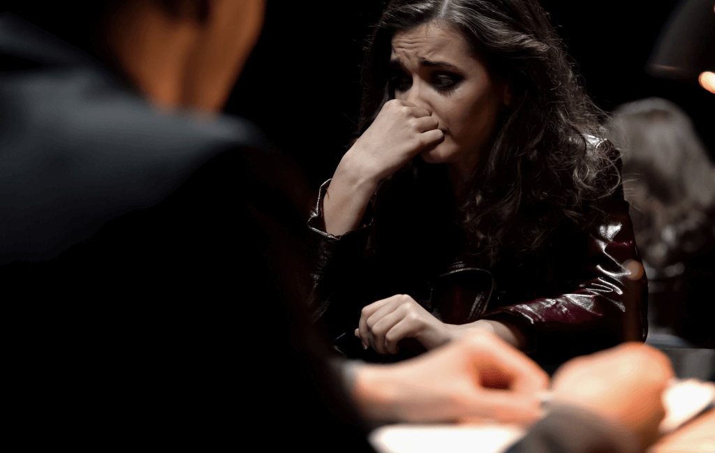 Brunette women sitting at a table looking guilty